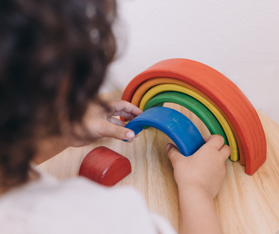 Child playing with wooden rainbow toy